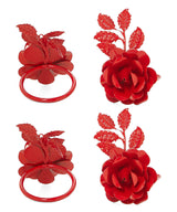 Four red metal napkin rings shaped like blooming roses with detailed leaves attached, shown from top-down and side angles on a white background.