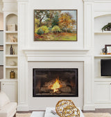 Framed autumn forest painting with orange and green foliage above a modern white mantel fireplace with a burning fire, flanked by built-in shelves and a TV.