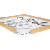 Black and white x-ray style floral print of crocus flowers with thin stems, shown framed in a light wood frame with a corner view on white background.