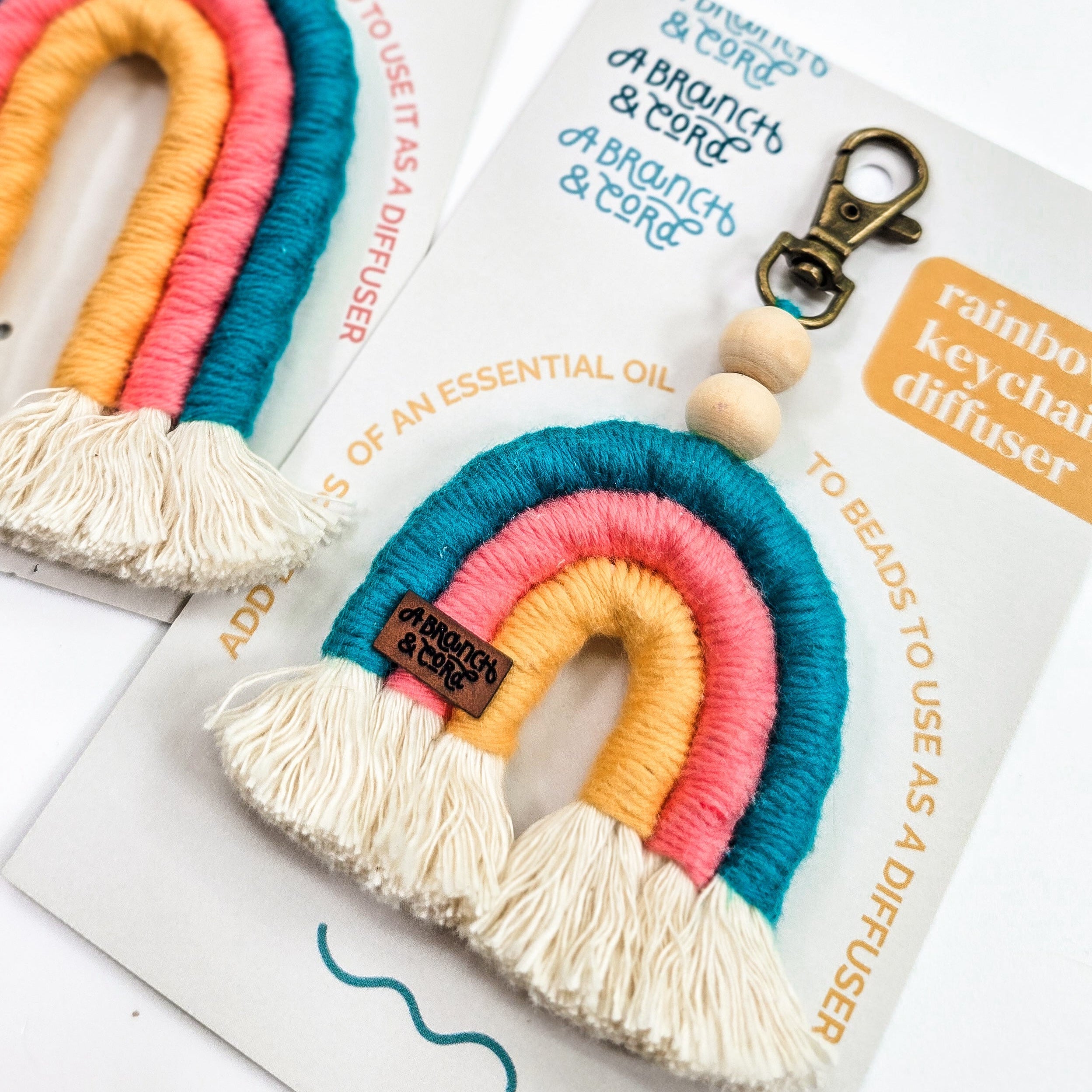 aB&c Diffuser Rainbows made of cotton rope and wooden beads hanging, showing colorful macrame in circular form