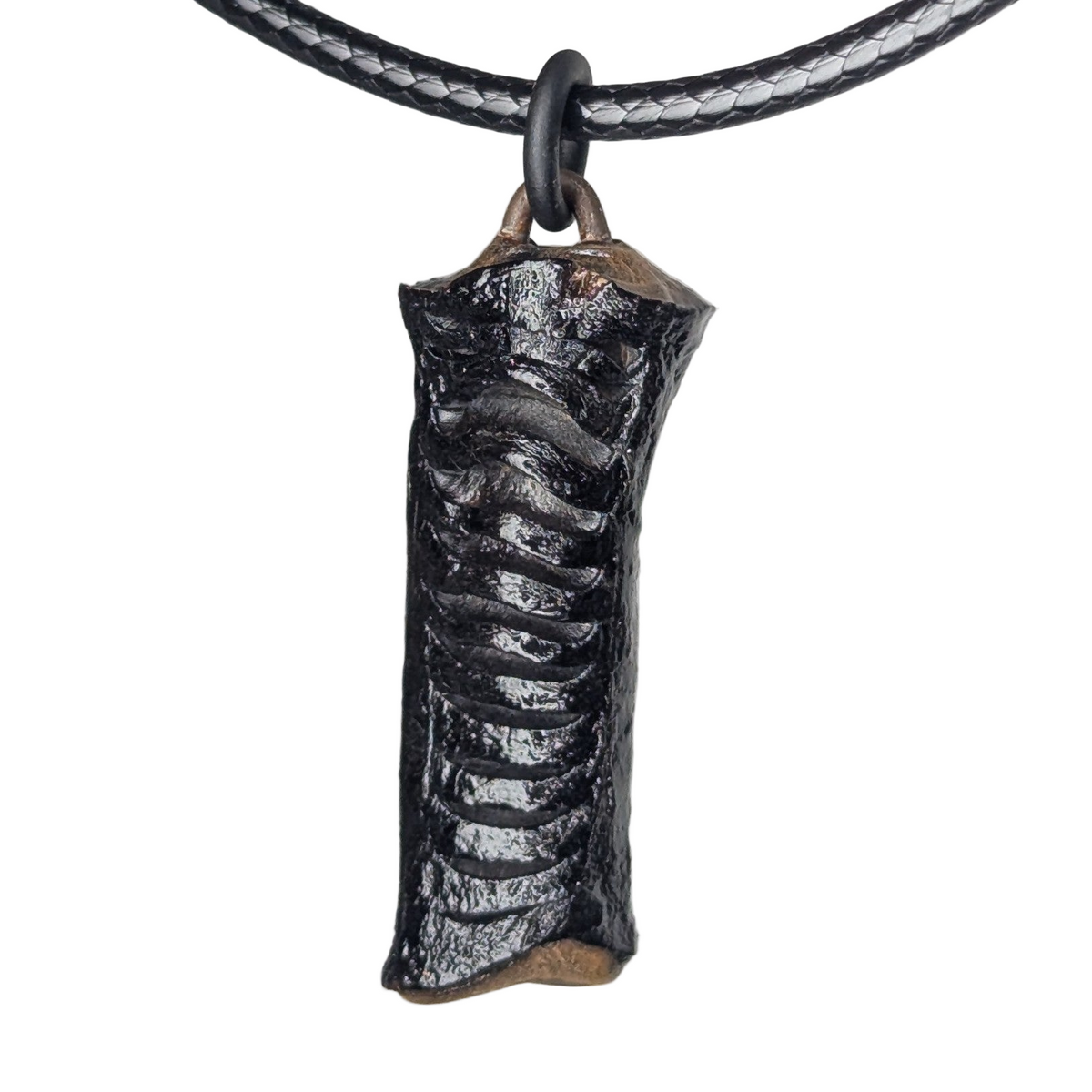 Calyra pendant necklace by Versiliy photographed on a dark surface with natural lighting