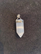 Translucent white selenite crystal pendant with pointed end, held by a sterling silver clasp against a dark textured background.