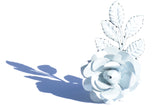 White metal napkin ring shaped like a rose with detailed petals and three attached leaves casting a blue shadow on a white surface.