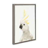 White cockatoo with yellow crest feathers looking to the side, displayed on a white canvas framed in a simple gray wooden frame.