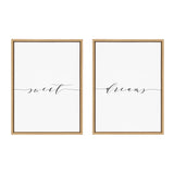 Two framed canvases with thin black cursive script reading 'sweet' and 'dreams' connected by a flowing line on a white background with light wood frames.