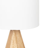 White cylindrical lampshade atop a light natural wood, faceted pyramid-shaped lamp base