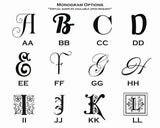 Grid of twelve stylized monogram letter options from A to L, showcasing various decorative serif and script fonts with floral and ornamental details.