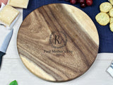 Round wooden charcuterie board with contrasting light and dark wood tones and an engraved 'First Mother's Day 2021' message surrounded by a decorative wreath.