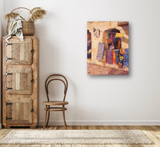 Painting of vibrant sarapes hanging outside a sunlit building with colorful textiles and a sunflower detail, displayed on a plain white wall above a wooden chair.