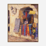Painting of vibrant woven fabrics including a multicolored striped sarape hung on a textured beige wall with a straw hat and sunflower decoration nearby.