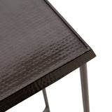Close-up of a black hammered metal square tabletop with a slightly raised edge, supported by slim round black metal legs on a white background.