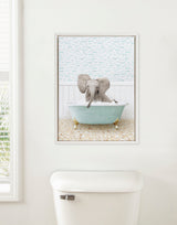 Framed canvas of a baby elephant bathing in a pale blue clawfoot tub against a patterned wall with small fish illustrations, hung above a white toilet.