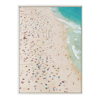 Framed canvas art depicting a crowded beach from above, with numerous small figures and umbrellas seen on the sand.