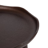 Close-up of a dark brown, round, slightly irregular textured tray with a raised edge and a subtle lip detail on one side, on a white background.