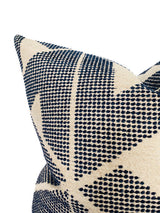 Close-up of a beige pillow cover featuring an indigo blue geometric pattern of small dots forming diagonal stripes and triangles.