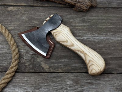 Small carving axe with carbon steel blade and ash wood handle, featuring leather sheath with belt loop