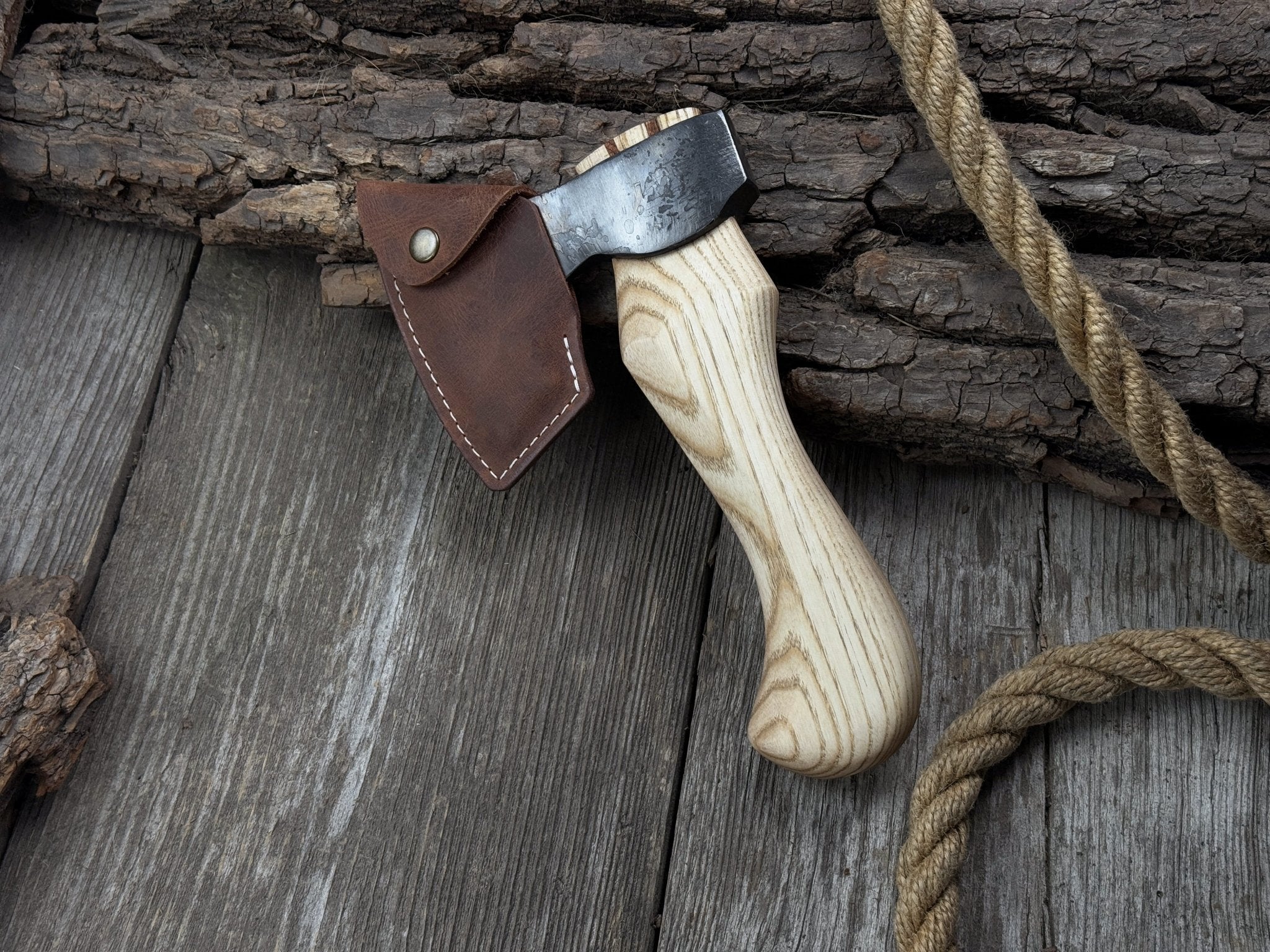 Small carving axe with carbon steel blade and ash wood handle, featuring leather sheath with belt loop