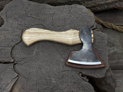 Small carving axe with carbon steel blade and ash wood handle, featuring leather sheath with belt loop