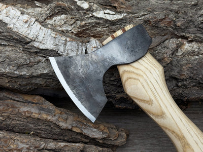Small carving axe with carbon steel blade and ash wood handle, featuring leather sheath with belt loop