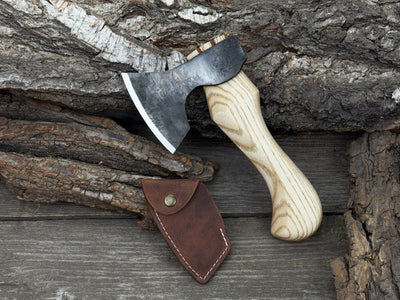 Small carving axe with carbon steel blade and ash wood handle, featuring leather sheath with belt loop