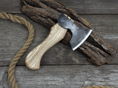 Small carving axe with carbon steel blade and ash wood handle, featuring leather sheath with belt loop