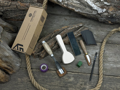 Spoon Carving Kit with bent gouge, whittling knife, wooden blank, sandpaper, sharpening board, pencil, and finger wrap