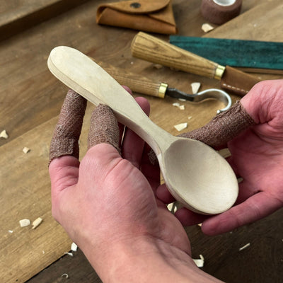 Spoon Carving Kit with wood carving knives, wooden blanks, sandpaper, and sharpening tools