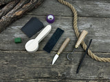 Spoon Carving Kit with knives, wooden blank, sandpaper, sharpening board, pencil, and finger wrap