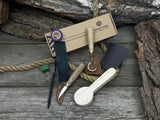 Spoon Carving Kit with knives, wooden blank, sandpaper, sharpening board, pencil, and finger wrap
