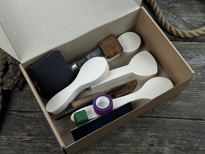 Spoon Carving Kit with hand-forged tools, wooden blanks, sandpaper, and sharpening board