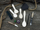 Spoon Carving Kit with hand-forged tools, wooden blanks, sandpaper, and sharpening board