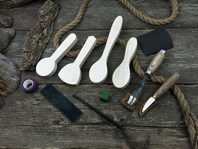 Spoon Carving Kit with hand-forged tools, wooden blanks, sandpaper, and sharpening board