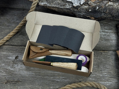 Complete spoon carving kit with knives, wooden blanks, sandpaper, sharpening board, pencil, and finger wrap