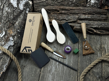 Complete spoon carving kit with knives, wooden blanks, sandpaper, sharpening board, pencil, and finger wrap