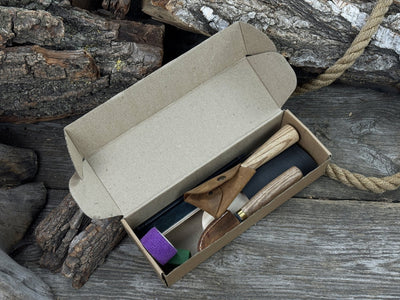 Spoon Carving Kit with knives, wooden blank, sandpaper, sharpening board, pencil, and finger wrap