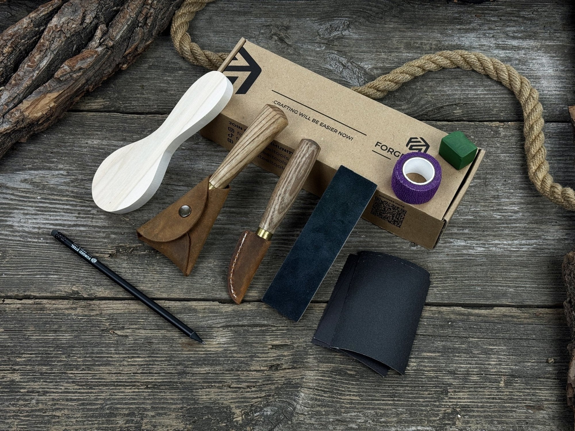 Spoon Carving Kit with knives, wooden blank, sandpaper, sharpening board, pencil, and finger wrap