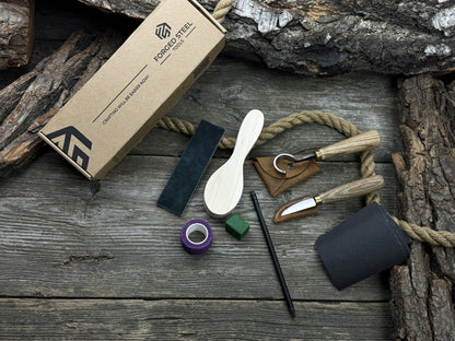 Spoon Carving Kit with knives, wooden blank, sandpaper, sharpening board, pencil, and finger wrap