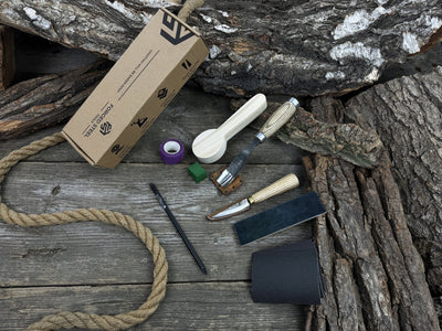 Spoon Carving Kit with knives, wooden blank, sandpaper, sharpening board, pencil, and finger wrap