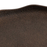 Close-up of a textured dark brown oval tray edge with subtle ripples and a slightly rough surface finish.