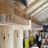 Stud Mounted Shed Storage Organizer brackets holding pipes and lumber inside a shed