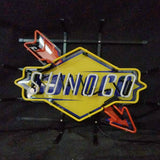 Neon sign with a yellow diamond-shaped background displaying the word 'SUNOCO' in blue letters, accented by red arrows above and below the text.