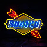 Neon sign displaying 'SUNOCO' in blue letters with red arrows crossing diagonally through a yellow diamond-shaped background on black.