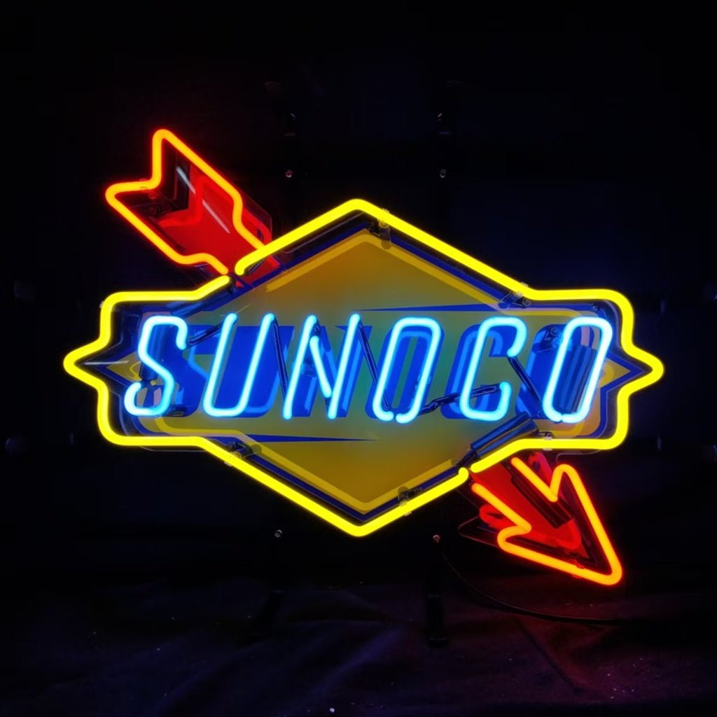 Neon sign displaying 'SUNOCO' in blue letters with red arrows crossing diagonally through a yellow diamond-shaped background on black.