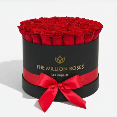 Black Supreme Box containing 26-28 naturally preserved red roses arranged tightly within.