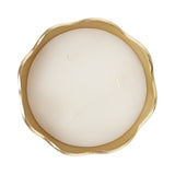 Round white candle with three wicks in a gold metal bowl featuring an irregular wavy rim, shown from above on a white background.