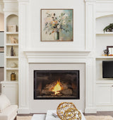 Framed floral botanical canvas with pastel leaves and flowers above a lit fireplace surrounded by white built-in shelves and cabinetry in a living room.
