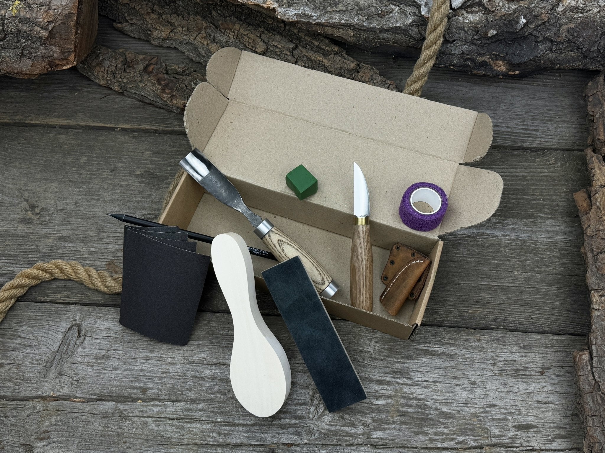 The Ultimate Beginner’s Spoon Carving Kit with tools, wooden blank, sandpaper, and sharpening board