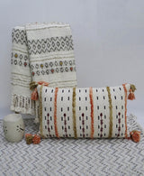 Colorful handwoven throw pillow with fringes on a sofa