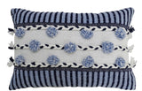 Striped throw pillow in blue and white with braided detail and tasseled fringe on sofa