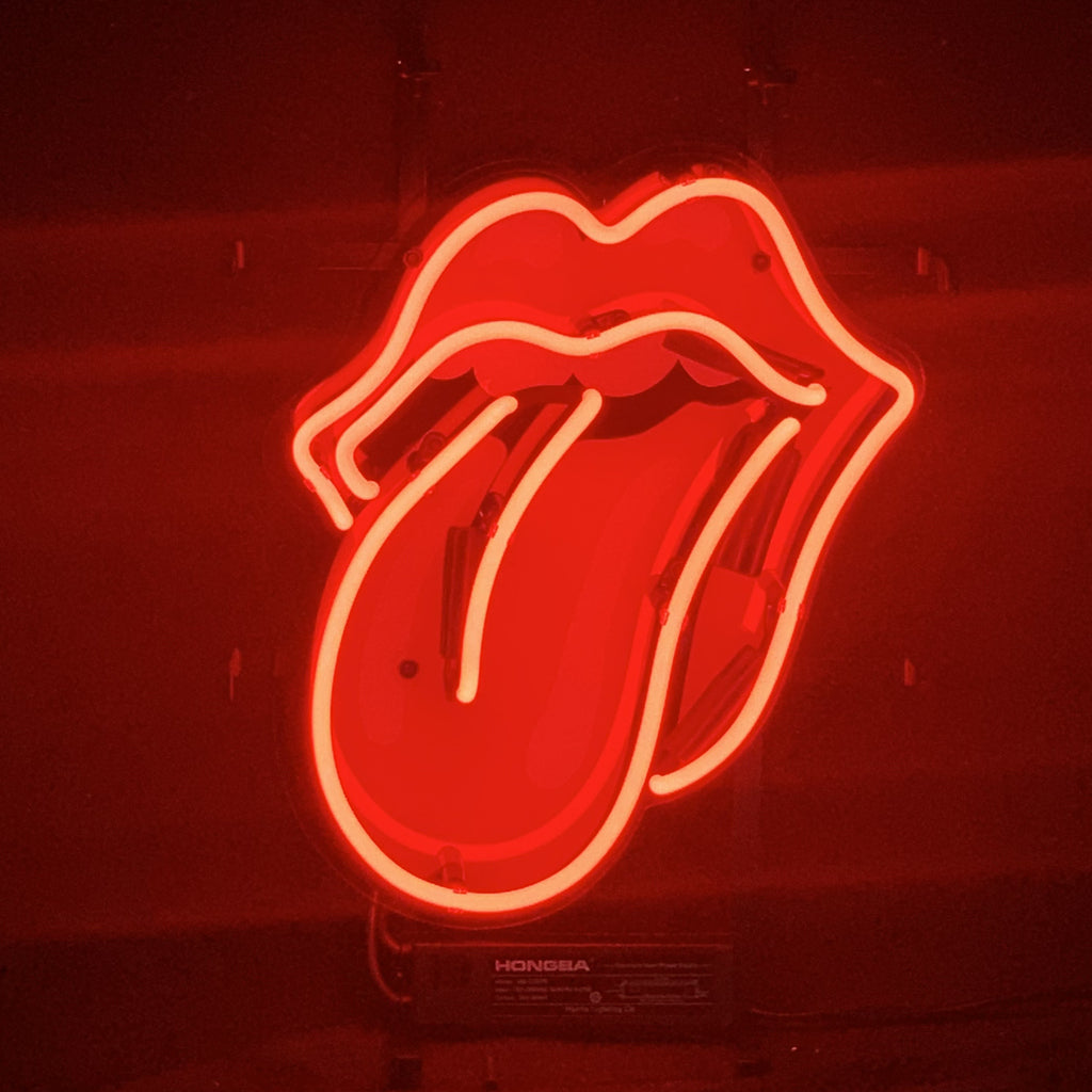 Red Rolling Stones Neon Sign Light glowing on a wall